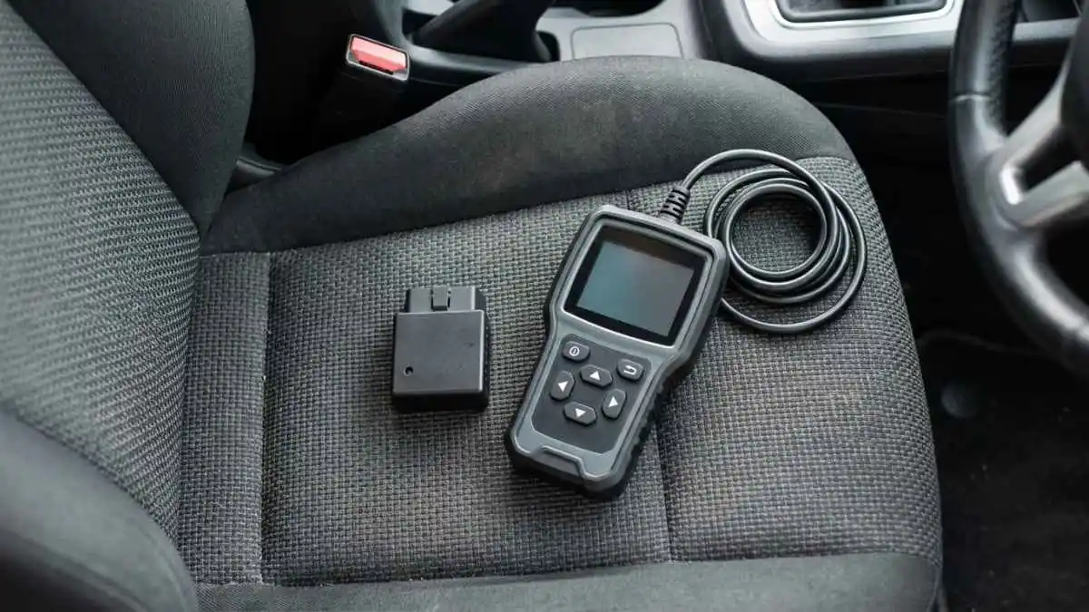 Bluetooth OBD2 dongle next to a handheld OBD2 scanner with a screen