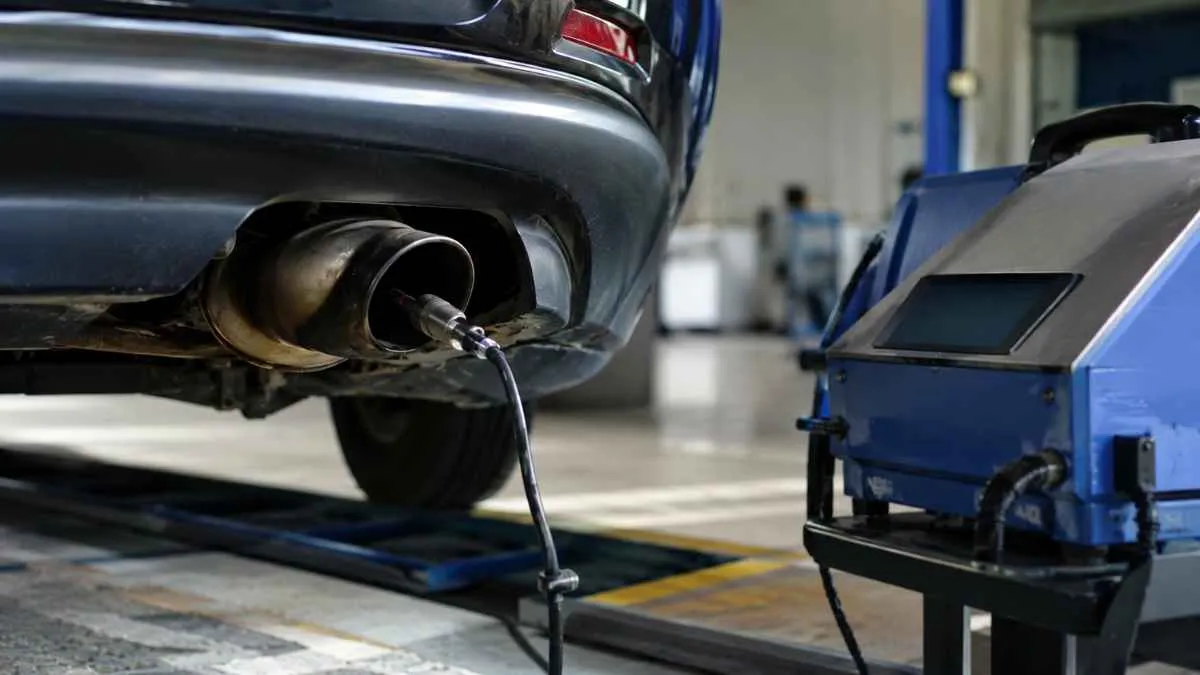 Car undergoing an emissions inspection with a diagnostic connection at a testing station